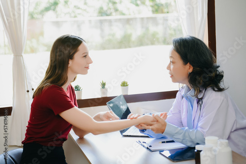  Woman being examined by a Senior doctor in background.