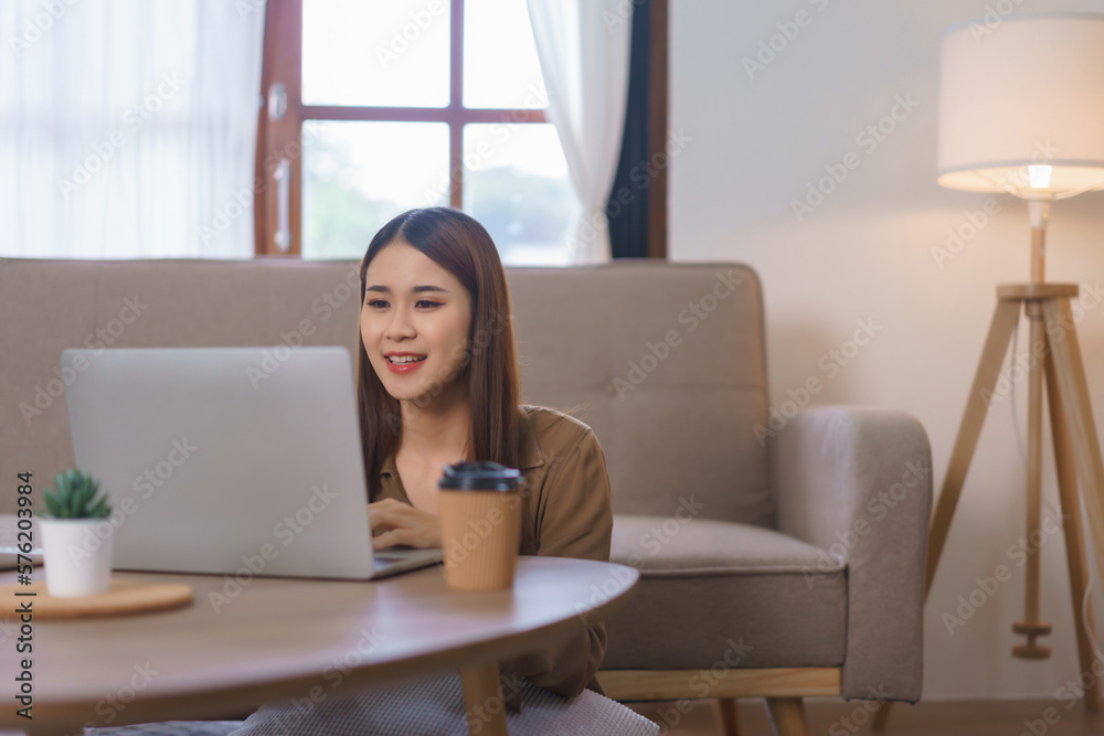 Working at home concept, Female freelance sitting on floor to working and shopping online on laptop Working at home concept, Female freelance sitting on floor to working and shopping online on laptop