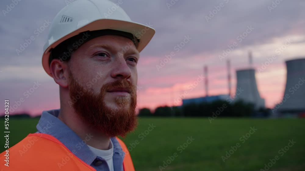 An engineer on the background of a power plant. The model looks away An engineer on the background of a power plant. The model looks away