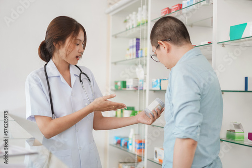 Medicine and health concept, Female pharmacist hold pill bottle to explaining medication for client