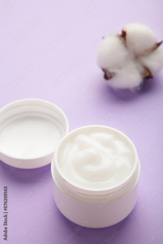 Jar with face cream beauty cosmetic product on purple background. Vertical photo