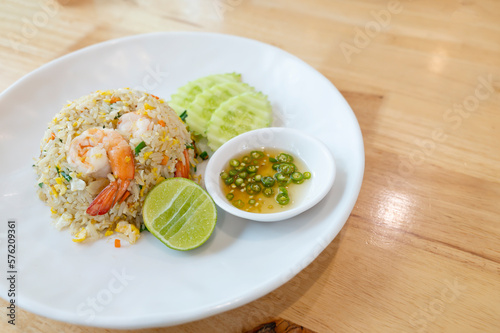Prawn fried rice on white plate on wooden table background