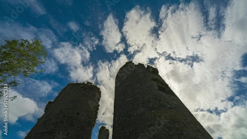 Time lapse of a Ballinafad Castle medieval ruin in rural countryside of Ireland with moving clouds on sunny day. photo