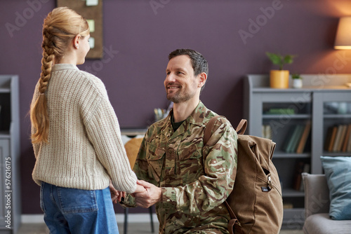 Portrait of loving father wearing military uniform holding hands with teen daughter © Seventyfour