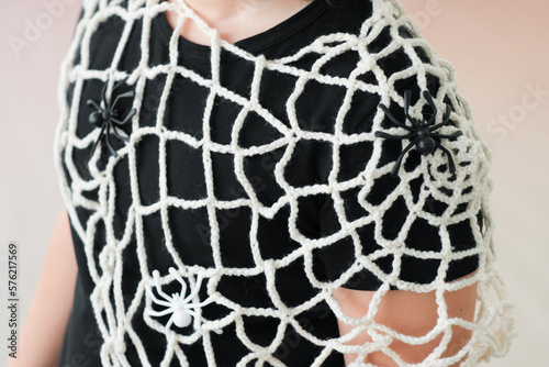 girl wearing knitted spider net on halloween party. Halloween celebrating, hand made costume