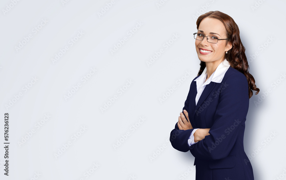 Portrait image of smiling young business woman standing profile side, folded hands, in confident suit, glasses, isolate light grey grey background. Executive office worker, teacher, real estate agent. Portrait image of smiling young business woman standing profile side, folded hands, in confident suit, glasses, isolate light grey grey background. Executive office worker, teacher, real estate agent.