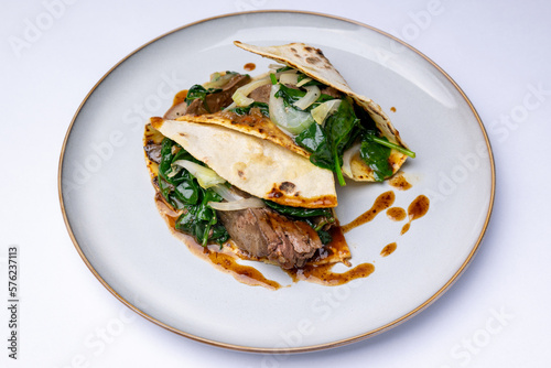 Potato pancakes with goose liver and steamed fresh spinach