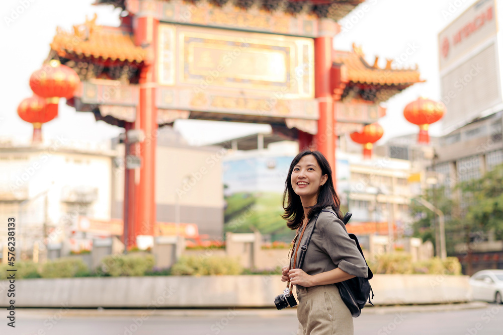 Young Asian woman backpack traveler enjoying China town street food market in Bangkok, Thailand. Traveler checking out side streets.