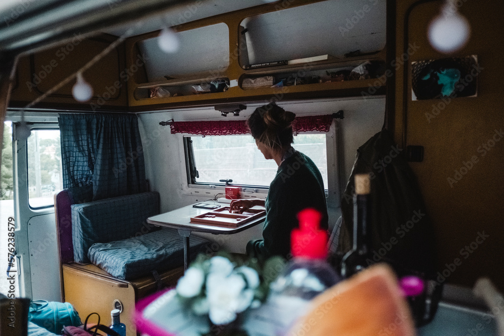 Woman playing board game in camper van Woman playing board game in camper van