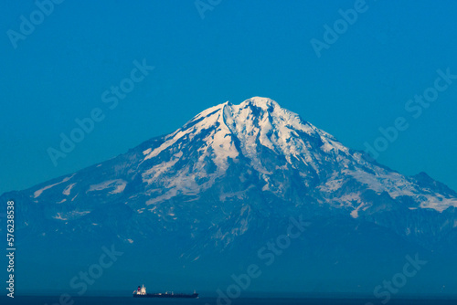 Mt Redoubt, an active volcano, last erupted in 2009. The volcano is seen here from near Homer Alaska on a cloudless day with a large ship.