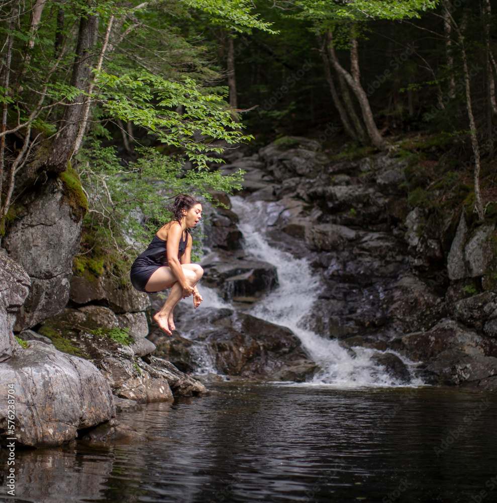 Woman jumping into water near Thirteen Falls, White Mountains, New Hampshire, USA Woman jumping into water near Thirteen Falls, White Mountains, New Hampshire, USA