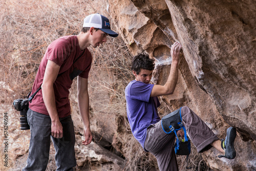 Rock climber figuring out the best way to climb the boulder in Hueco Tanks State Park, Texas photo