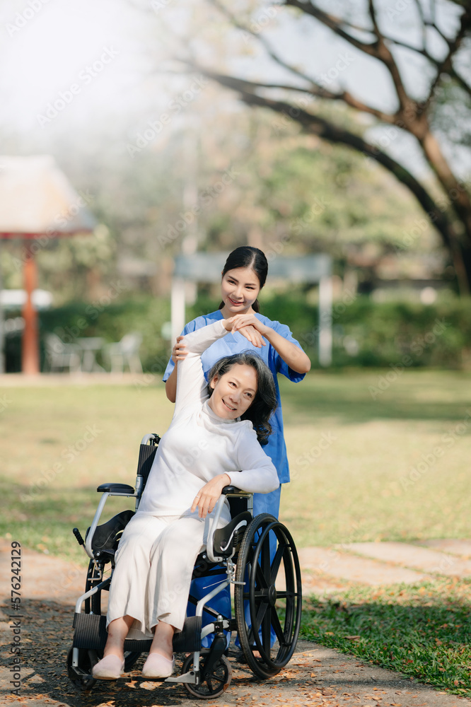 Asian careful caregiver or nurse and the happy patient in a wheelchair are walking in the garden to help and encourage and rest your mind with green nature. Asian careful caregiver or nurse and the happy patient in a wheelchair are walking in the garden to help and encourage and rest your mind with green nature.