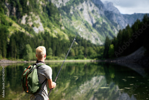 Fisherman fishing in nature at lake while camping outdoor