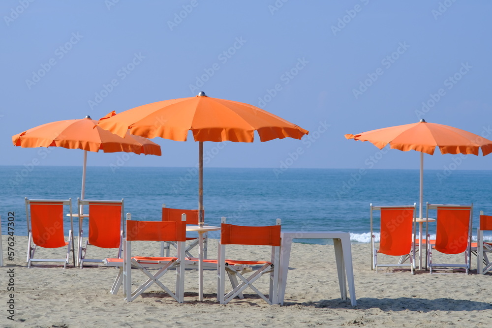 Versilia. Umbrellas on the beach. The sea of Viareggio in Versilia. In the background a yacht. 