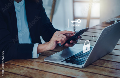 Two steps authentication (2FA) concept. Key icon and password code showing on smart phone while businessperson login on laptop computer, Identity verification, cybersecurity technology.
