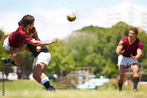 Working together for stronger unity. Shot of a young rugby player executing a pass mid-tackle. © Cameron M/peopleimages.com