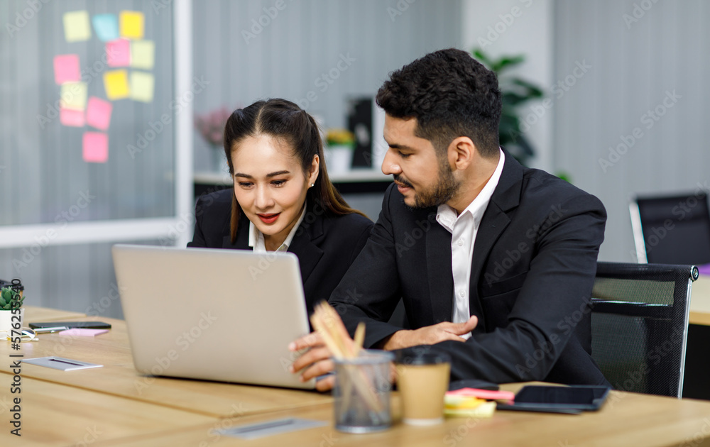 Millennial Asian Indian professional bearded male businessman female businesswoman employee staff in formal business suit sitting working typing laptop notebook computer in company office workplace Millennial Asian Indian professional bearded male businessman female businesswoman employee staff in formal business suit sitting working typing laptop notebook computer in company office workplace