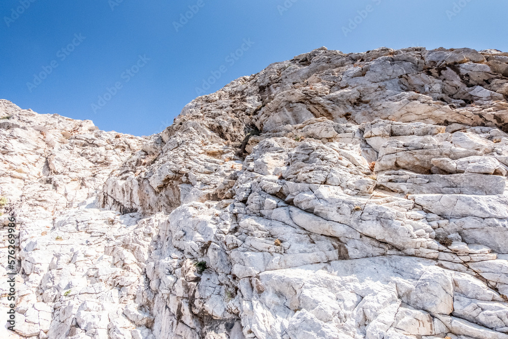 Irregular rock face with blue sky in the background on a beautiful warm sunny day in Santoniri.