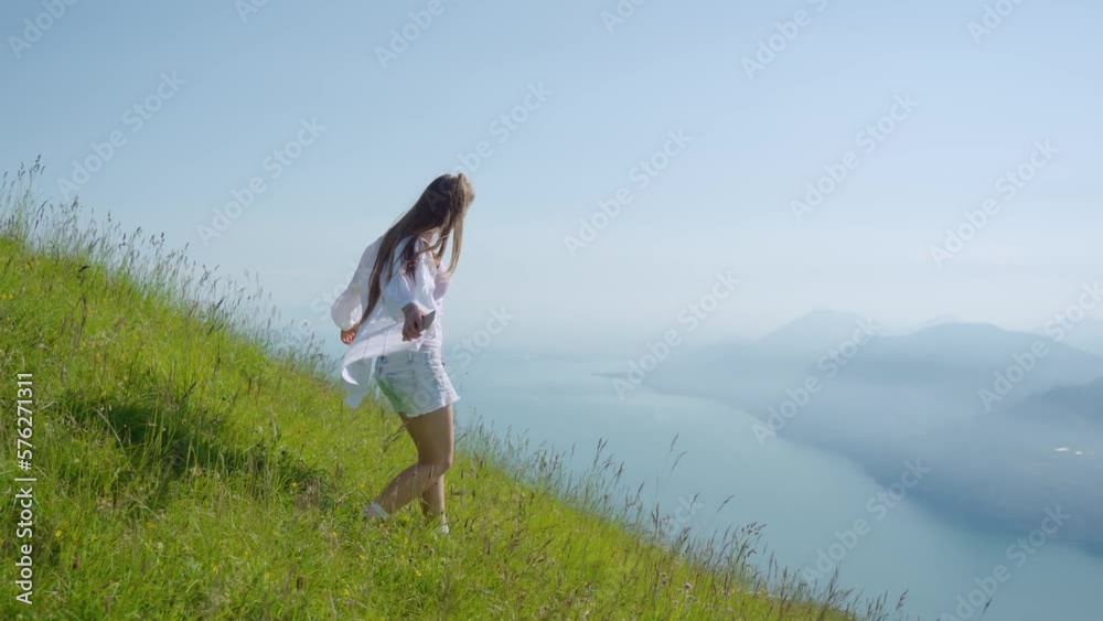 Girl walks on the grass with a beautiful panorama of Lake Garda Girl walks on the grass with a beautiful panorama of Lake Garda