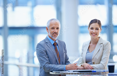 Old talent, new talent. Portrait of a mature businessman standing with a younger female colleague.