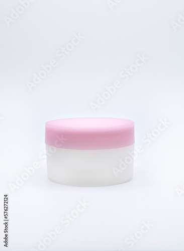 pink cosmetic bottle, cream and lid isolated on background
