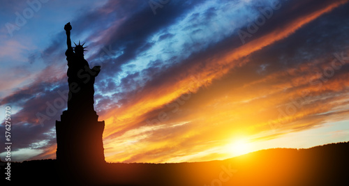 Silhouettes of The Statue of Liberty at sunset. Greeting card for Independence Day. USA celebration.