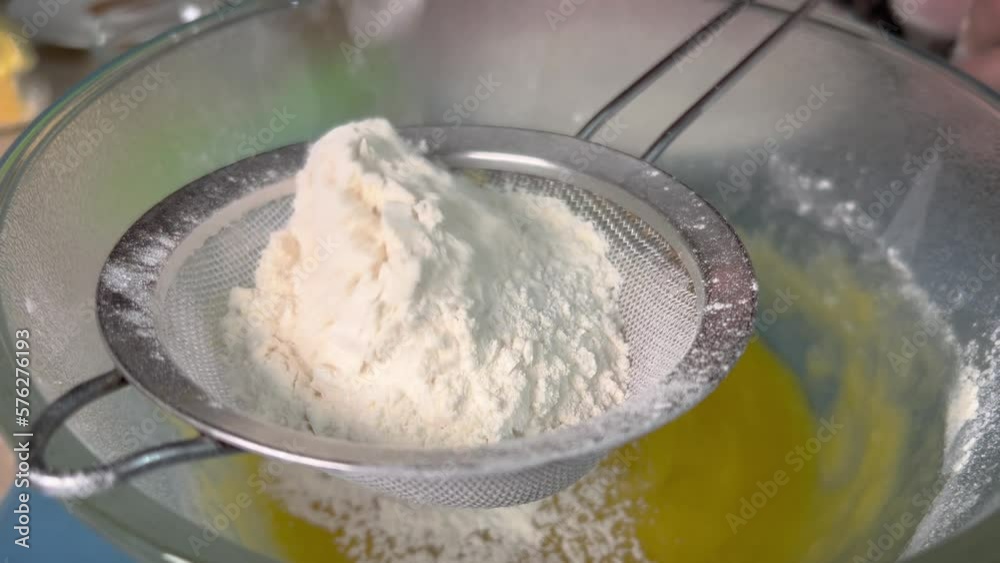 Putting flour on a sieve to sift it when making dough. Putting flour on a sieve to sift it when making dough.