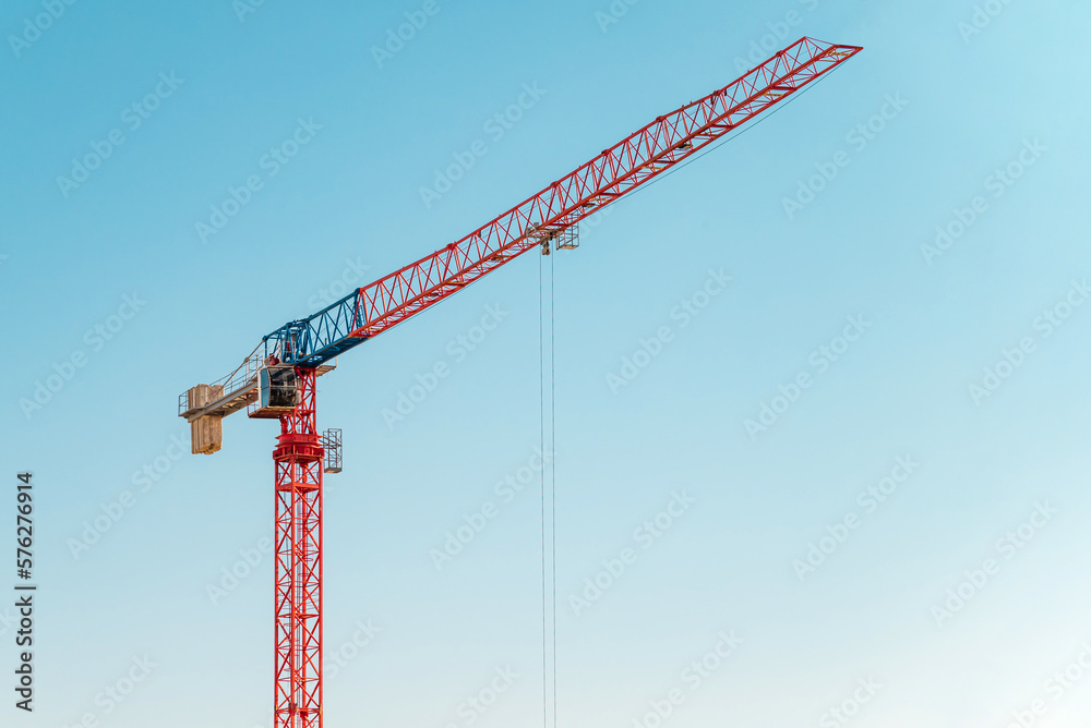 Construction crane in front of cloudless sunny blue sky Construction crane in front of cloudless sunny blue sky