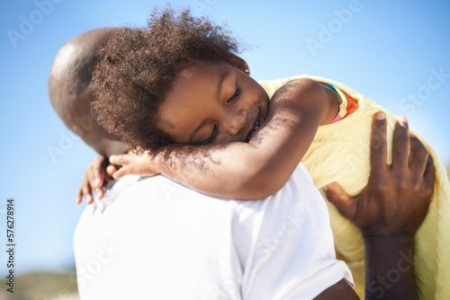 I love you, dad. An adorable african-american falling daughter asleep on her fathers shoulders at the beach. photo