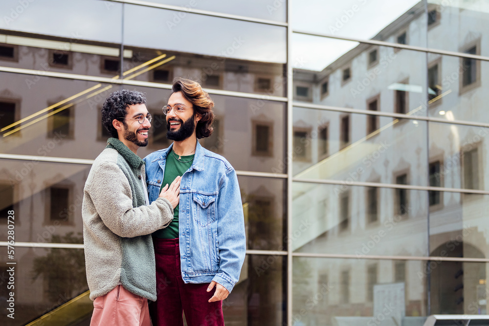 Obraz premium couple of gay men smiling happy and hugging tenderly, concept of freedom and love between people of the same sex, copy space for text