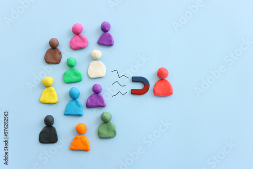 Concept image of a magnet attracting a group of people. metaphor of media influence and human resources