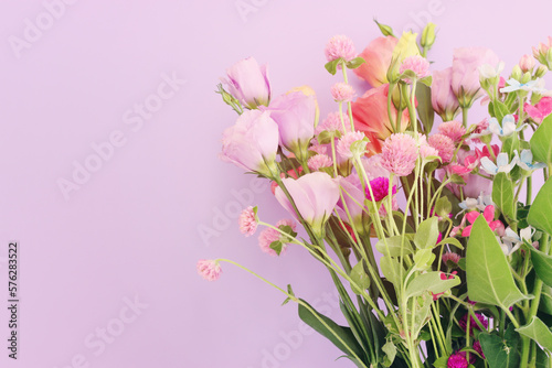 Top view image of pink and purple flowers composition over pastel background © tomertu