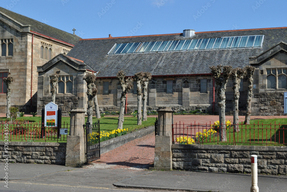 Entrance Gate and Garden of Old Victorian Stone Church beside Quiet Road Entrance Gate and Garden of Old Victorian Stone Church beside Quiet Road