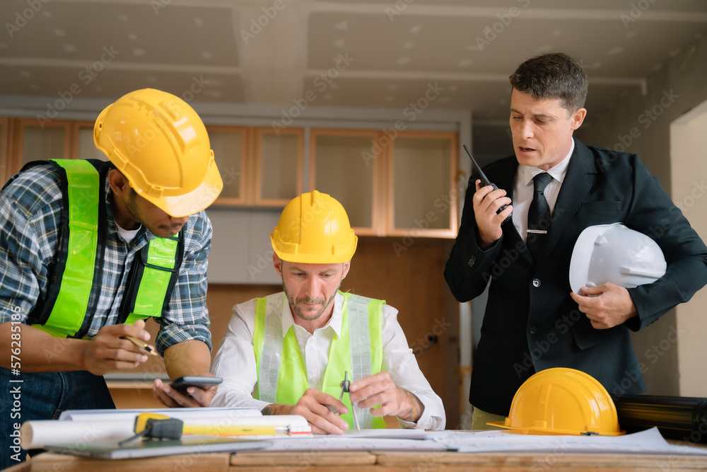 Working as a team architect and designer working on blueprint project of new apartments. Photo concept of work on technical drawings in construction site. Working as a team architect and designer working on blueprint project of new apartments. Photo concept of work on technical drawings in construction site.