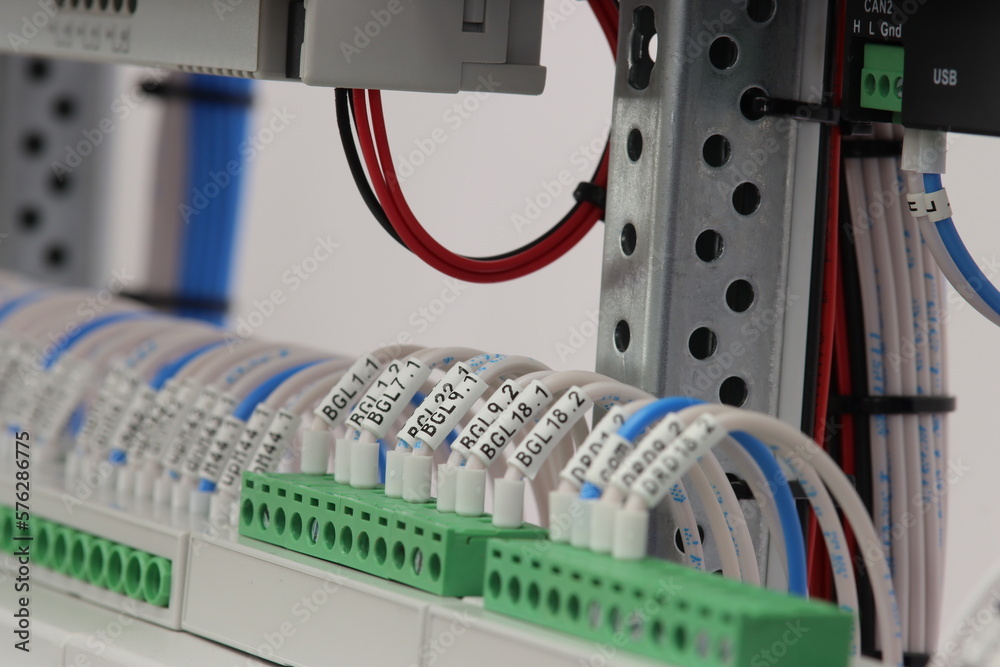 Electrical screw terminals with connected insulated copper wires with metal tips. The wires are marked with thermal printing.