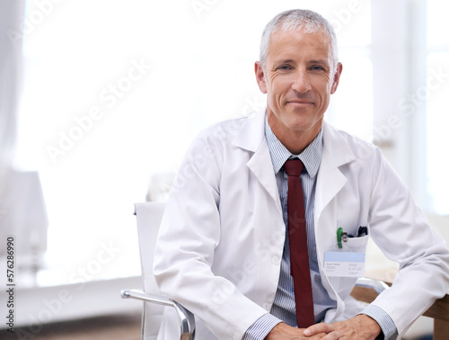 Im here to help. Portrait of a male doctor sitting in his office.