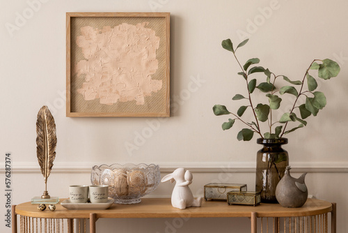 Tableau sur toile Interior design of easter living room interior with mock up poster frame, glass vase with leaves, wooden sideboard, easter bunny sculpture, glass bowl and personal accessories