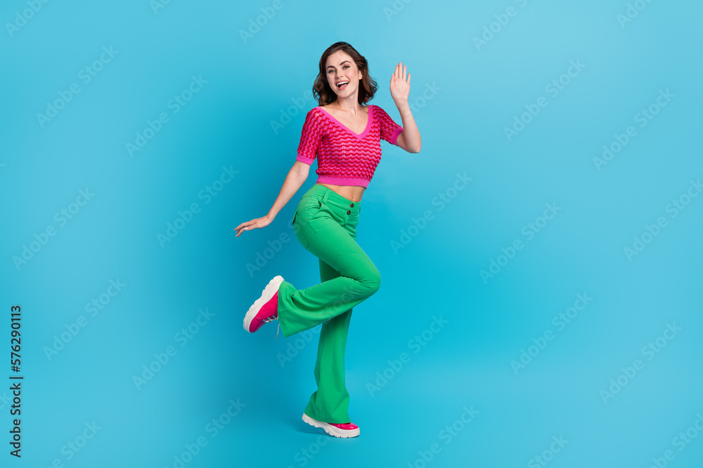 Full size photo of gorgeous good mood satisfied woman with wavy hairstyle wear pink top saying hi isolated on blue color background
