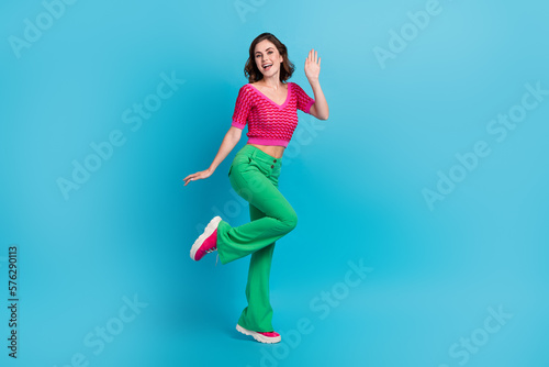 Full size photo of gorgeous good mood satisfied woman with wavy hairstyle wear pink top saying hi isolated on blue color background