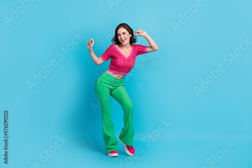 Full size photo of gorgeous sweet woman with wavy hairstyle wear pink top dancing look empty space isolated on blue color background