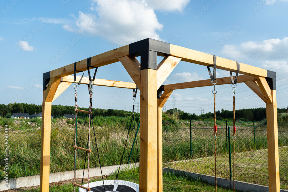 A modern cubic playground made of wooden logs and metal corners, visible nylon ropes and clip hook. A modern cubic playground made of wooden logs and metal corners, visible nylon ropes and clip hook.