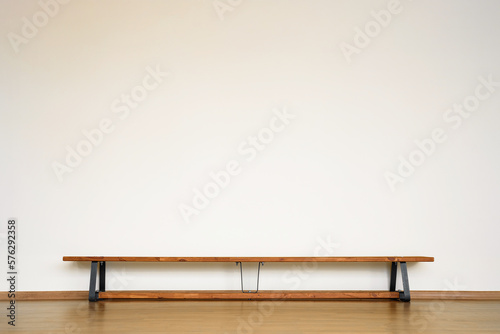 Single wooden sport bench standing on floor in gymnasium room. Gymnastics bench indoor of school room for physical exercise.