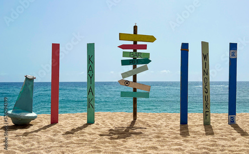 Empty colorful wooden direction sign on the beach, image for vacation concept and inspiration.