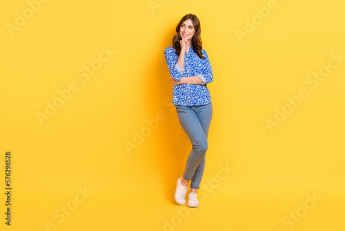 Full length photo of nice satisfied cheerful person hand touch chin look empty space isolated on yellow color background