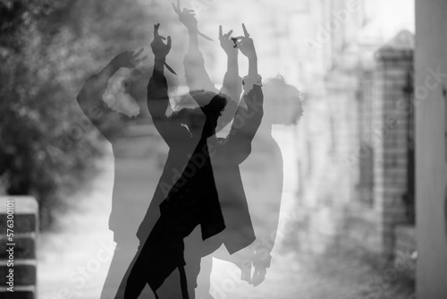 Silhouette of guy dancing on ciity street, multiple exposure photo