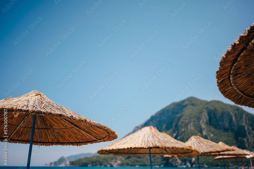 Straw umbrellas on mountain and blue sky background