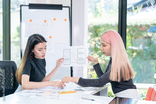 Two Young and beautiful creative female designer making a sketch while sitting at her workplace in the office. Web design. Creative occupations. Business and career. UX UI design