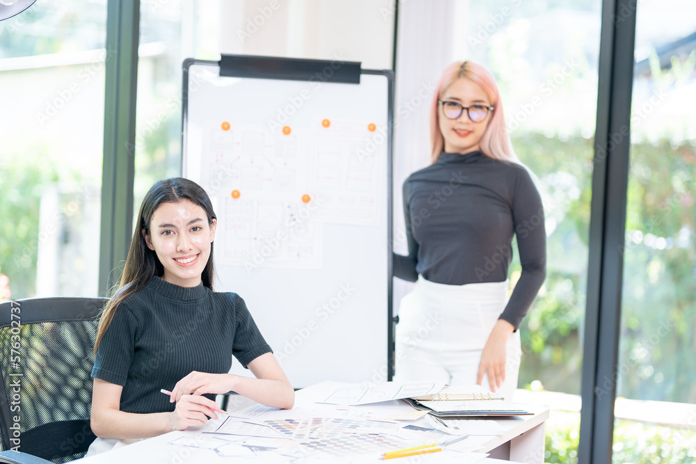 Two Young and beautiful creative female designer making a sketch while sitting at her workplace in the office. Web design. Creative occupations. Business and career. UX UI design Two Young and beautiful creative female designer making a sketch while sitting at her workplace in the office. Web design. Creative occupations. Business and career. UX UI design