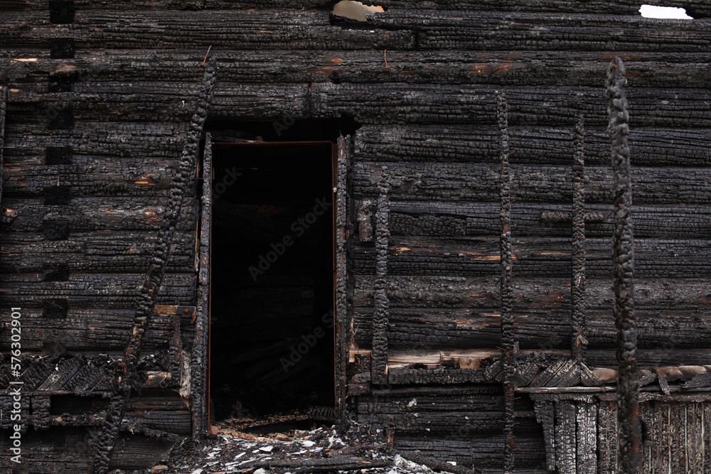Burned wooden house, black remains of construction Burned wooden house, black remains of construction